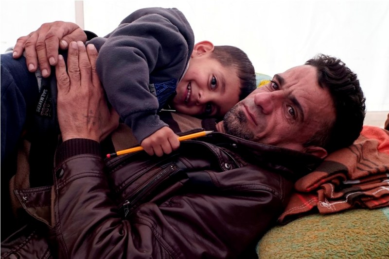 29 Novembre 2015 - Un padre iraniano abbraccia suo figlio di quattro anni in un campo improvvisato al confine greco-macedone nei pressi della città di Idomeni.